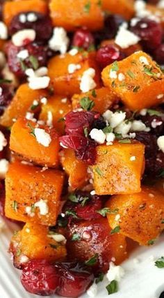 a white plate topped with carrots and cranberries covered in feta cheese