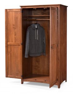 an open wooden wardrobe with a jacket hanging on the door