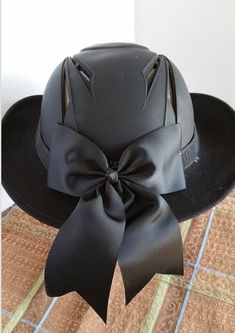 a black hat with a big bow on it