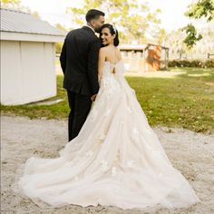 a bride and groom standing in front of a barn