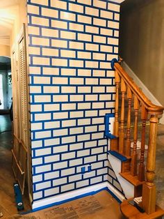 a stair case next to a blue and white brick wall