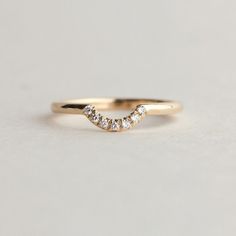 a gold wedding band with three small diamonds in the shape of an o - ring