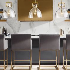 the modern dining room is decorated in gold and grey tones with glass pendants hanging from the ceiling