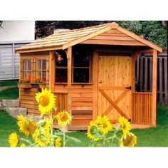 a garden shed with sunflowers in the foreground