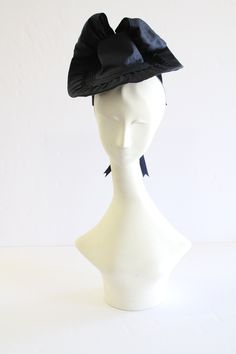 This listing is for a One-of-a Kind hand sewn 1940's Vintage style Navy Blue Silk fascinator tilt hat. 100% Silk Dupioni over buckram Satin ribbon Finished and labeled inside hat Best secured with a hat pin or hair pins One Size Fits Most I hope you enjoy this hand made hat from my Fall 2023 Collection.  Made entirely by hand by Jennifer Serr Victorian Fitted Hats For Costumes, Victorian Fitted Costume Hats, Victorian Style Fitted Costume Hats, Victorian Fitted Brimmed Costume Hats, Vintage Formal Headpiece With Curved Brim, Fitted Cloche Headpiece For Vintage Events, Vintage Fitted Cloche Headpiece, Fitted Fascinator For Costume Occasions, Vintage Mini Hats With Curved Brim For Costume