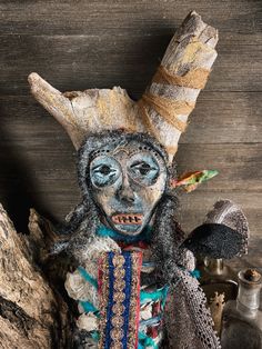 a wooden table topped with a statue of a person wearing an animal mask and headdress