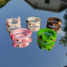 four different bracelets sitting on top of a glass table with trees in the background