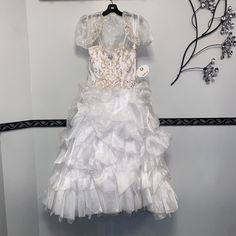 This Kids Dress Features Beautiful Jewel Accents, A Fluffy Skirt, Matching Bolero Jacket, With Back Corset Closure. Short Sleeve Ruffled Princess Dress For Pageant, White Princess Dress With Ruffles For Fancy Dress, White Ruffled Pageant Dress For First Communion, White Pageant Dress With Ruffles, Princess Style White First Communion Dress With Ruffles, White Ruffled Dress For Fancy Dress, White Ruffled Dress For Fancy Dress Occasion, White Ruffled Fancy Dress, White Ruffle Dress For Fancy Occasions