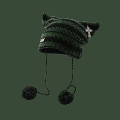 a black and green striped hat with pom - poms