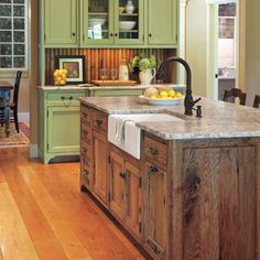 a large kitchen with an island in the middle and lots of cabinets on both sides