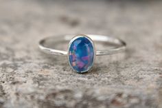 I am super excited to finally show off these new opals! I have been working with a wonderful supplier who specially made these gemstones just for my shop, so you will not find them anywhere else! This listing is for ONE light blue 8mm X 6mm oval opal ring! These crystal opals are more translucent with a nice amount of fire and sparkle! Each 1.3mm band is made using Argentium sterling silver. I hand forge each band, fuse them together, solder on the fine silver bezel cups, then put them in my tum Stackable Opal Birthstone Ring For Promise, Stackable Opal Birthstone Promise Ring, Stackable Opal Promise Ring, Minimalist Stackable Opal Ring, Dainty Opal Gemstone Stackable Rings, Dainty Opal Stackable Rings With Gemstones, Opal Stackable Rings With Birthstone For Promise, Minimalist Opal Stackable Promise Rings, Oval Opal Stackable Rings As Gift