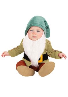 a baby dressed in a gnome costume sitting on the ground with his hands out to the side