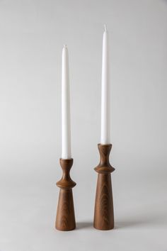 two white candles sitting next to each other