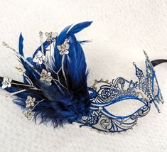 Navy & Blue Metal Masquerade Mask with Feathers Blue metal masquerade mask decorated with clear Austrian crystals, and blue & silver holographic glitter. Navy tiger tuft feathers and metal & crystal butterflies complete this gorgeous mask. Hand made in Australia. Ribbon ties. Laura Lucci Collection. NOTE: Shipment is via Australia Post, check their website at: https://auspost.com.au for estimated delivery times to your location. Mask With Feathers, Crystal Butterflies, Mask Venetian, Party Mask, Australia Post, Costume Mask, Masquerade Mask, Mask Party, Holographic Glitter