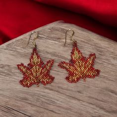 Add a touch of elegance and bohemian charm to your look with our exquisite handmade seed bead earrings. Each pair is meticulously crafted with love and attention to detail, ensuring that no two pairs are exactly alike. These earrings make a thoughtful and unique gift for birthdays, anniversaries, or just because. Red, amber, and gold leaf pattern. Made with high quality seed beads. Gold filled ear wires 3.1 x 3.5 cm. Packed in a velveteen gift bag.  Ready to ship. This is not an original design. Gold Beaded Dangle Earrings For Gifts, Festive Gold Beaded Earrings, Gift Gold Beaded Earrings, Handmade Gold Beaded Earrings With Czech Glass, Traditional Gold Beaded Earrings As Gift, Handmade Teardrop Beaded Earrings With Czech Glass, Handmade Teardrop Czech Glass Beaded Earrings, Handmade Czech Glass Beaded Teardrop Earrings, Festive Beaded Teardrop Earrings