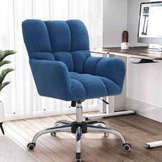 a blue office chair sitting in front of a computer monitor