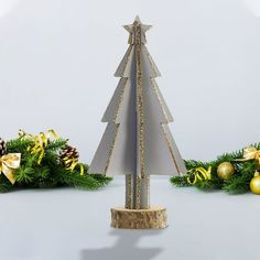 a paper christmas tree with gold ornaments around it