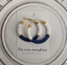 "+ Style name: Navy White and Gold Clay Beaded Hoops + beaded dangle hoop earrings with blue, and white clay heishi beads and gold bead accent + Hoops are 1 1/2\" diameter + gold hoops with lever back closure + available in 2 variations - Navy with White and Gold Pink and Gold + All lizcorcreative hoop earrings will come packaged on a hand-stamped kraft earring card in a clear sealed bag Free Domestic Shipping Follow along Instagram https://www.instagram.com/lizcorcreative/ Facebook https://www. Flat Clay Bead Earrings, Flat Bead Earrings, Heishi Earrings Diy, Polymer Clay Bead Earrings, Clay Bead Earrings Ideas, Nautical Jewelry Diy, White Bead Earrings, Clay Bead Earrings, Heishi Earrings