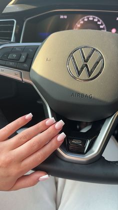 a woman's hand on the steering wheel of a car