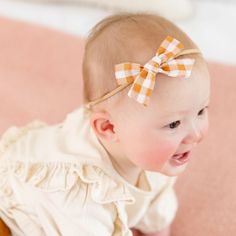 The Baby Bow on Nylon in Mustard Gingham This adorable hair bow is the perfect accessory for your babe! Baby Bows are 3" wide and attached to a comfortable nylon headband. Imported. White Headband For Spring Playtime, White Summer Headband For Playtime, Summer White Headband For Playtime, White Summer Headband, Cute Cotton Headband For Playtime, Adjustable Bow With Matching Headband For Spring, Playful White Bow With Matching Headband, Cute Bow Hair Accessories For Playtime, Adjustable Cotton Bow - Cute Style