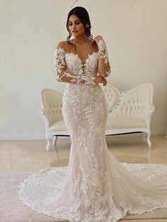 a woman in a wedding dress posing for the camera with her hands on her hips