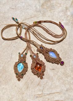 🌙 Show off your celestial style with this beautifully hand-crafted Series of Statement Gemstone Macrame Necklaces. A delightful combination of refined craftsmanship and raw natural beauty, this gemstone choker embraces the spirit of boho chic and adds a touch of whimsy to any outfit. 🏹 Highlighting the uniqueness of your personality, this macrame jewelry piece showcases delicate weaving methods, artisanal techniques, and meticulous attention to detail.  🔮 As a centrepiece, the ethereal moonstone captures the heart of the mystical moon's charm. Known widely as a stone for 'new beginnings', its luminous surface reflects a shimmering array of blues and silvers, creating a captivating play of light. 💎Each crystal necklace is adorned with authentic semi-precious stones, all ethically source Bohemian Handmade Moonstone Necklace, Handmade Bohemian Moonstone Gemstones, Handmade Brown Labradorite Necklace, Artisan Hand Wrapped Moonstone Necklaces, Artisan Hand Wrapped Moonstone Necklace, Bohemian Labradorite Gemstones As Gifts, Handmade Amethyst Amulet Necklace, Bohemian Moonstone Gemstone Crystal Necklaces, Handmade Unique Moonstone Crystal Necklace