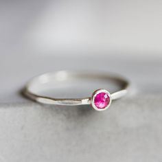 Tiny skinny stackable ring with Ruby stone. The ring is made with a skinny but sturdy band, which allows you to create mind-blowing stacking sets! Some of the rubies I have a natural and some lab-created. Let me know if you have any preferences on which stone to use for your ring. The ring is 0,8-0,9 mm thick and looks very dainty on the finger. Choose the size of the stone (3 or 5 mm) and material for the ring (sterling silver or 9k gold). You can also choose the stone finish - smooth or rose c Minimalist Stackable Birthstone Toe Ring, Minimalist Stackable Toe Ring Birthstone, Minimalist Stackable Toe Birthstone Ring, Everyday Birthstone Ring With Bezel Setting, Everyday Sterling Silver Birthstone Ring, Simple Stackable Birthstone Ring As Gift, Minimalist Birthstone Ring With Bezel Setting, Dainty Stackable Ruby Ring For Promise, Everyday Gemstone Stackable Rings With Round Band