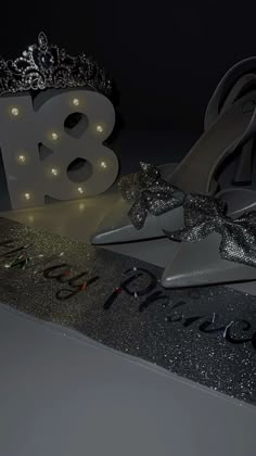 a pair of high heeled shoes sitting on top of a black and silver sign