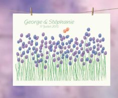 a wedding card hanging on a clothes line with purple flowers in the foreground and butterflies in the background