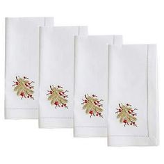 four white christmas napkins with embroidered holly designs