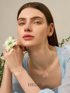 a young woman is holding a flower in her left hand and posing for the camera