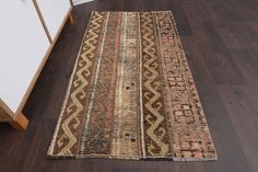 an old rug is laying on the floor in front of a dresser and cabinet with drawers