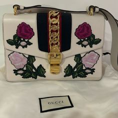 The Perfect Spring Bag! This Is The Limited Edition Gucci White Leather Sylvie Handbag With Embroidered Flowers, Gold Chain Detail And A Leather Removable Strap. This Bag Is Stunning!!!! Only Used Once Bought From Poshmark Two Years Ago With Be Authenticated. The Best Gucci Bag For Spring Summer And Beyond Classy! Gucci Sylvie Bag, Gucci Sylvie, Gucci Floral, Spring Bags, The Limited, Toscana, Embroidered Flowers, Sling Bag, Gucci Bag