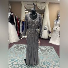 This Elegant Plus Size Long Dress Features Long Sleeve Square V-Neckline With An Intricate Sequin Pattern That Shines Through With Every Movement. Accentuate The Waist With A Satin Belt. Perfect For Any Special Occasion. Silver Size 12 (B38 W28 H41) Sequin V-neck Evening Dress For Mother Of The Bride, Formal Beaded V-neck Evening Dress, V-neck Embellished Gown For Mother Of The Bride, Sequined Floor-length Mother Of The Bride Dress, Glamorous Sequined Mother Of The Bride Dresses, Glamorous Sequined Dresses For Mother Of The Bride, Beaded V-neck Evening Dress For Wedding, Glamorous V-neck Dress For Mother Of The Bride, Embellished V-neck Gown For Mother Of The Bride