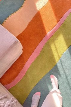 a person laying on the floor with their feet up next to some blankets and pillows