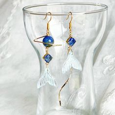 Mermaid Tail and Blue Planet Earrings Our Mermaid Tail and Blue Planet Earrings are perfect as a gift, with carefully crafted mermaid tails and brilliant blue planets encapsulated in sterling silver frames. Quality jewelry, sure to capture and captivate the gaze of its admirers. As a gift shop, we offer a complimentary gift box for every order. Detail: Length of earring - around 80mm; size of bead - around 8mm Material: ear wire - sterling silver; wire and drops - gold-plated bronze; beads - lapis lazuli bead Note: the Mermaid Tail and Blue Planet Earrings are handmade locally in the UK, each pieces would vary slightly in detail.  About postage: Standard postage When choosing standard postage, we assume this order is for yourself, or you will wrap the item yourself before giving it out as Ocean-inspired Single Earring As Gift, Ocean-inspired Blue Dangle Earrings, Blue Dangle Earrings With Ocean-inspired Style, Ocean-inspired Blue Earrings With Ear Wire, Ocean-inspired Blue Earrings For Gifts, Handmade Mermaid Earrings For Gift, Blue Ocean-inspired Dangle Jewelry, Celestial Blue Single Earring, Silver Wreath