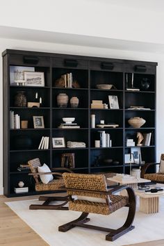 a living room filled with furniture and bookshelves next to a wall mounted book case