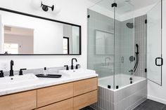 a bathroom with two sinks and a large mirror above the bathtub is seen in this image