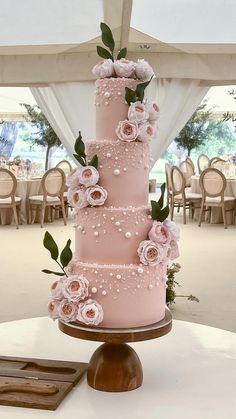 a pink wedding cake with flowers on top