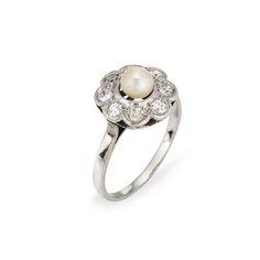 This is part of Chairish’s Fine Jewelry assortment.  Stylish antique Edwardian pearl & diamond cluster ring crafted in platinum topped 18k white gold (circa 1900s to 1910s). One center set pearl measures 5mm, accented with eight estimated 0.06 carat old single cut diamonds. The total diamond weight is estimated at 0.48 carats (estimated at H-I and SI1-I2 clarity).    The classic cluster design highlights a halo of diamonds surrounding the creamy center set pearl. The ring is great for wear as an Heirloom White Gold Pearl Ring With Rose Cut Diamonds, Victorian Pearl Ring With Diamond For Anniversary, Victorian White Gold Pearl Ring For Formal Occasions, Classic Cluster Pearl Ring For Wedding, Classic Pearl Ring With Single Cut Diamonds For Wedding, Classic Wedding Pearl Ring With Cluster Shape, Antique White Gold Pearl Ring For Formal Occasions, Victorian Style White Gold Pearl Ring For Formal Occasions, Formal Pearl Ring With Rose Cut Diamonds