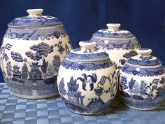 three blue and white jars sitting on top of a table