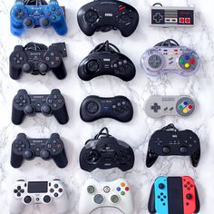 a collection of video game controllers sitting on top of a marble counter next to each other