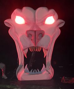 an illuminated dragon head in the dark with its mouth open