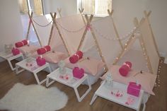 several teepee tents are set up in a room with pink and white decor on the walls