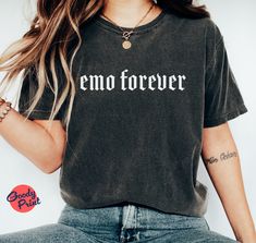 Embrace your inner elder emo kid with our Elder Emo Unisex T-Shirt. This shirt combines the aesthetic appeal of pop punk, pastel goth, and an overall emo vibe. Made with high-quality materials, it offers comfort and style for all genders. Whether you're feeling nostalgic for your emo roots or simply appreciate the alternative aesthetic, this shirt is a perfect addition to your wardrobe. It's not just a shirt; it's a statement piece that showcases your unique style. Whether you're attending a concert, expressing yourself through fashion, or simply reminiscing about your emo days, this shirt is designed to make you feel confident and empowered. So, embrace your grown-up emo self and rock this Elder Emo Unisex T-Shirt with pride! PRODUCTION TIME: 1-3 Days (Typically 2 Days) SHIPPING TIME: 2-5 Slogan T-shirt For Alternative Fashion, Emo Style Short Sleeve Top For Concert, Grunge Letter Print Top For Alternative Fashion, Edgy Halloween Tops With Text Print, Emo Letter Print Short Sleeve Top, Emo Short Sleeve Top With Letter Print, Trendy Halloween Concert T-shirt, Short Sleeve Emo Top With Letter Print, Trendy Halloween T-shirt For Alternative Fashion