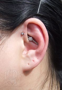 a close up of a person's ear with two piercings on top of it