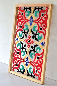 a wooden frame with a cross stitch pattern on it