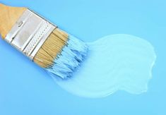 a paint brush with white bristles on it's tip and light blue background