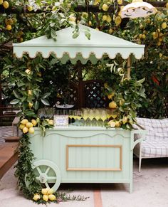 a lemonade stand is set up in the middle of a garden with lots of greenery