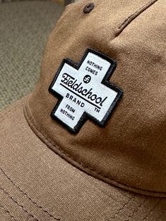 The Fieldschool Brand cross patch is a classic featuring our ‘Nothing Comes From Nothing” mantra. Rugged waxed cotton with knitted construction Relaxed unstructured shape Five-panel pinch front Precurved visor Cotton sweatband 100% Polyester Hat constructed by Richardson Brown Cotton Baseball Cap With Logo Patch, Brown Cotton Hat With Logo Patch, Casual Cotton Hat With Waxed Finish, Brown 5-panel Baseball Cap With Logo Patch, Texas Snakes, Cross Patch, Lady Bird Lake, Lucky Shirt, Sun Cap